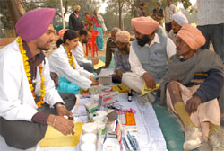 Protesting doctors attending to patients in OPD services while sitting on mats in front of the mini-secretarait in Bathinda