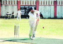 A batsman plays a defensive stroke at the 57th District Cricket League at Survey Stadium, Dehradun on Friday.