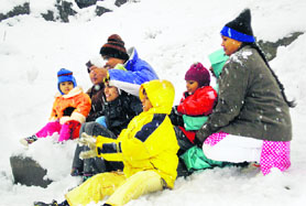 Tourists enjoying in fresh snowfall near Nehru Kund on the Manali-Rohtang road on Friday.