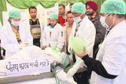 Agitating rural doctors attend to patient Punjab government in Bathinda on Sunday.