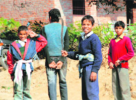 Children with sickles in their hands going to forest to collect firewood at Amlela village near Nagrota Soorian in Kangra district.