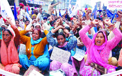 Members of the Dalit Dasta Virodhi Andolan hold a dharna outside the residence of PPCC president Mohinder SIngh Kaypee in Jalandhar