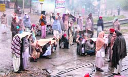 Farmers block the Bathinda-Ferozepur rail track in Bathinda on Tuesday.