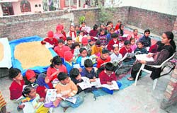 A teacher holds a class on the roof of a house in Ludhiana. 