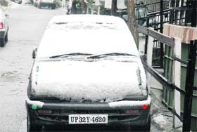 A car is fully covered with snow which fell at Shimla