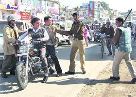 Policemen prevent students from getting shops forcibly closed during the bandh in Dehradun