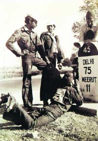 Sanghara Singh prays at a milestone near Meerut as (L-R) Anand Mishra, Gopal Bhardwaj and Gurucharan Singh Hora look on in February 1975