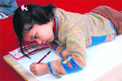 Oblivious of people around her, a girl is busy making a painting at a fair in Dehradun.