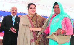 Deputy Commissioner Deepti Umashankar honours Kiran, the first customer of the solar home-lighting system of Iqbalpur village in Gurgaon, at a function organised in the village