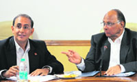 ICC chief executive Haroon Lorgat (L) talks with ICC vice-president Sharad Pawar during the ICC Cricket World Cup Organising Committee meeting in New Delhi 