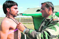 An Army officer measures the chest of an applicant during a recruitment drive in Baramulla