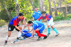Players vie for the ball at the PN Dhasmana Memorial Hockey Tournament in Dehradun on Thursday.