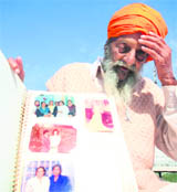 Ishar Singh shows photographs of his family in Jammu.