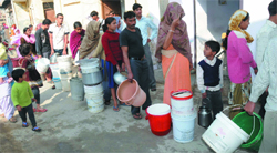 People queue up for water at Shahabad Mohammadpur in New Delh