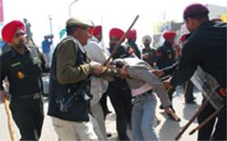 Cops and commandos (above) take away a protester from the Fauji Chowk in Bathinda on Sunday