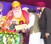 CM Parkash Singh Badal presents a picture of the Golden Temple to Brahmarishi Shri Kumar Swami in Amritsar on Sunday.