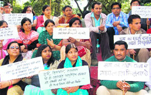 Visiting and contractual lecturers observe fast at the Gandhi Park in Dehradun on Monday.