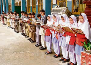 Students read books after their school was reopened in Swat Valley on Monday