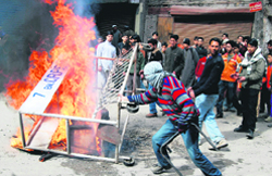 Protesters burn tyres to block the road in front of a CRPF camp in Srinagar 