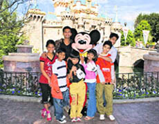 Child actors from Slumdog Millionaire celebrate the film's Oscar win for Best Picture with Mickey Mouse at Sleeping Beauty Castle at Disneyland in Anaheim, California.