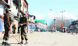 CRPF jawans stand guard as a curfew-like situation prevails in Srinagar on Wednesday in protest against the Sopore firing. 