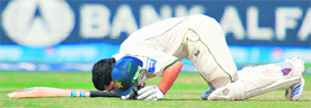 Pakistans Kamran Akmal kisses the ground after completing his century during the fifth and final day of the first Test against Sri Lanka in Karachi on Wednesday.