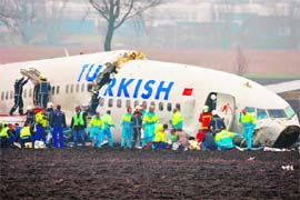 Rescue workers help passengers after a Turkish Airlines passenger plane crashed while attempting to land at Amsterdam's Schiphol airport on Wednesday. The plane broke into three parts when it hit the ground next to the runway.