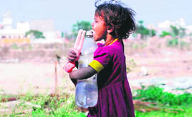 A girl carries water for her parents in Karnal.