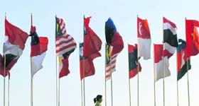 A woman walks past flags of the member nations ahead of the 14th Association of Southeast Asian Nations Summit in the Thai resort city Hua Hin, about 200 km south of Bangkok