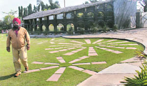 Landscapist B.P. Singh alongside the sun motif that he's created with concrete tiles