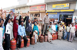 Consumers protesting against the supply of underweight LPG cylinders at an outlet in Bathinda on Tuesday.