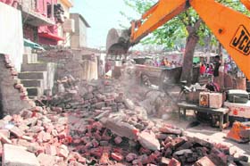 A JCB machine razes structures during an anti-encroachment drive at Bapu Dham Colony in Sector 26, Chandigarh