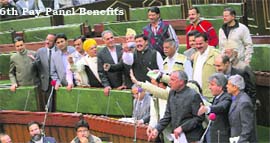 Enraged members up on their feet over Finance Minister AR Rathers reply on 6th pay panel reports implementation before they stage a walkout from the Assembly in Jammu on Tuesday.