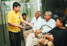 A child volunteer explains Metro etiquette and discipline to commuters on Pragati Maidan to Rajiv Chowk stretch in New Delhi on Wednesday. The week is being observed as the Metro Safety Week.