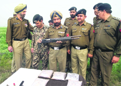 Himmat Singh Gill, IG, BSF, and officials look at arms seized from Pakistani smugglers