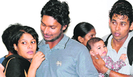 Kumar Sangakkara (C) hugs his wife Yehali (L) and Thillakeratne Dilshan (R) holds his son upon their return to the island