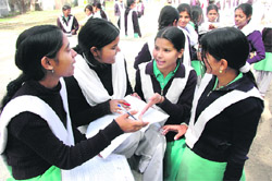 Students of Government Girls Inter-College at Rajpur Road discuss the paper after the Class X examination on Thursday in Dehradun.