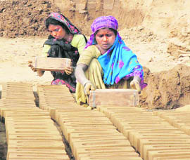 Women labourers work at a brick-kiln near Barota village in Karnal.