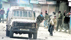 Agitators attack a police vehicle during a protest in Srinagar