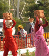 A woman carries bricks at a construction site in Bathinda.