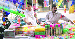 People buy items for Holi from a stall at Civil Lines market in Roorkee.