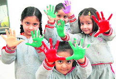 Schoolchildren of Times World School celebrate Holi on Saturday.