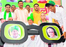Supporters present a replica of the INLD symbol to party supremo Om Prakash Chautala as former Union Minister of State for Home ID Swami looks on during the vijay sankalp rally in Karnal