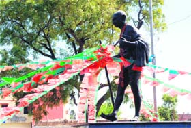 BANKING ON BAPU: It seems even the BJP and the INLD cannot do without the support of Mahatma Gandhi and have tied party flags to his statue in Karnal