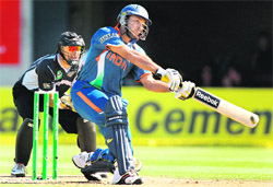 Yuvraj slams a ball to the boundary as wicketkeeper Peter McGlashan (L) looks Christchurch on Sunday.