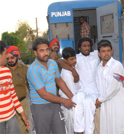Binder Singh, an undertrial lodged at the Bathinda jail, being brought out of a police lorry on his return from the Mansa courts, outside the jail on Monday.