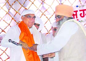 Chief Minister Bhupinder Singh Hooda being presented with a siropa at Gurdwara Manji Sahib in Lakhanmajra village in Rohtak district