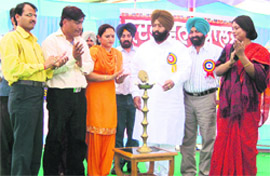 Bikramjit Singh Khalsa, Parliamentarian Secretary for technical education, lights a lamp to launch a community awareness drive by Sadbhavna Society at Jallaldiwal village on Tuesday.