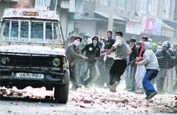Stone-throwing protesters target a police vehicle in Srinagar