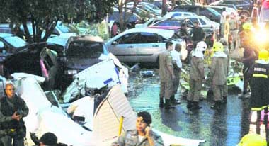Investigators inspect the single-engine Embraear Tupi airplane that crashed in the parking lot of a shopping mall in Goiania, some 100 miles southwest of Brasilia